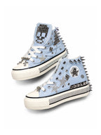 Baby blue studded high-top sneakers with spikes, rhinestones and chain trim on white background