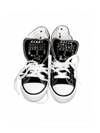 Black studded high-top sneakers front top view with skull tongue studs and white laces
