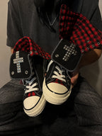 Red check cross studded high-top sneakers handheld detail view