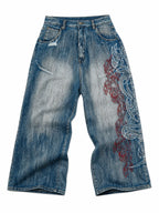 The Tribal Flame Embroidered Jeans in blue, natural flat lay on a pure white background, front view