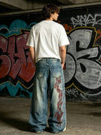 The "Tribal Flame" Embroidered Jeans styled on model, graffiti wall back view