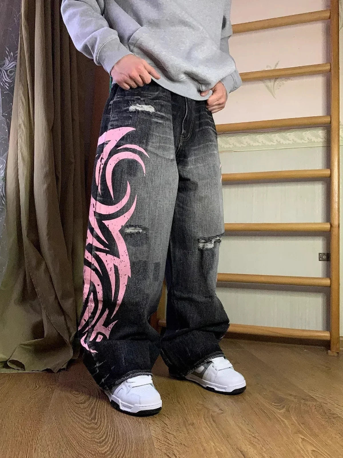 Black and pink Tribal Halo washed wide-leg jeans styled indoors, angled front view