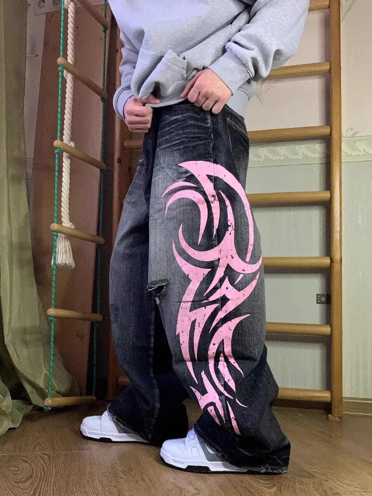 Black and pink Tribal Halo washed wide-leg jeans styled indoors, side view