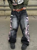 Black and pink Tribal Halo washed wide-leg jeans in an industrial setting, close front view