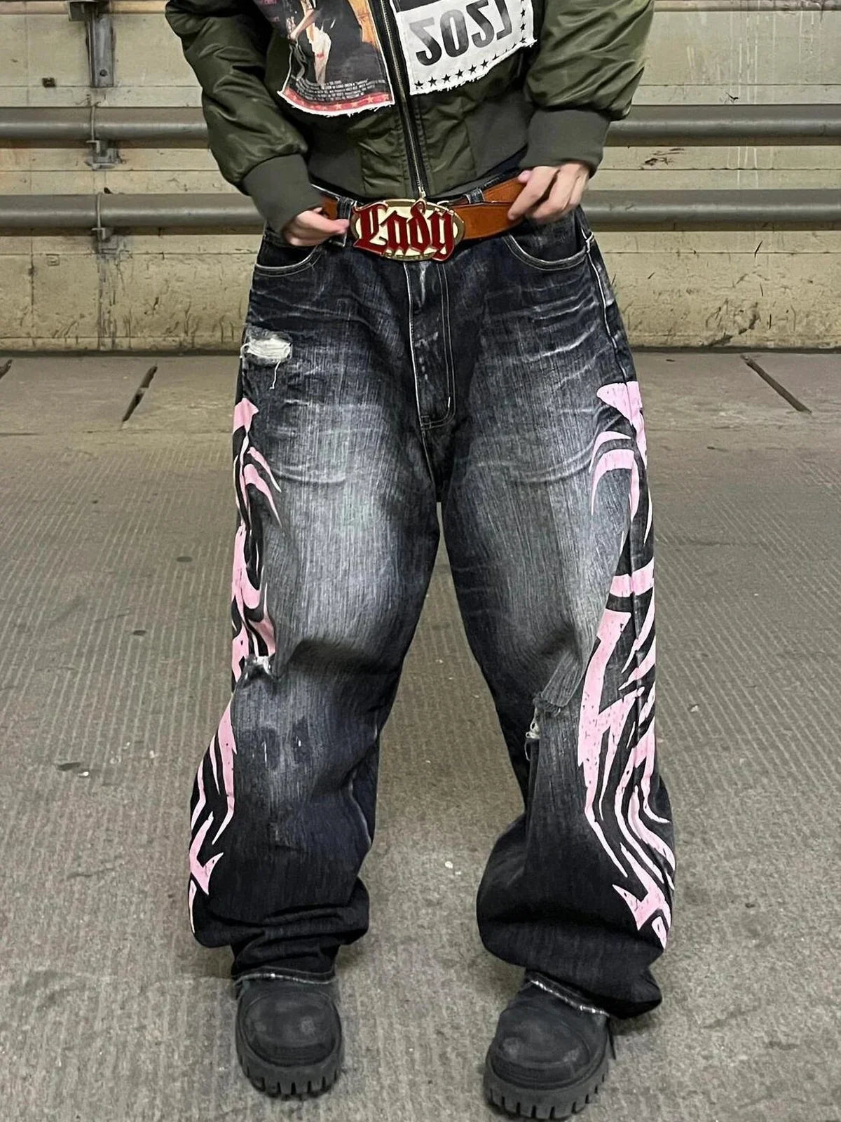 Black and pink Tribal Halo washed wide-leg jeans in an industrial setting, close front view