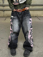 Black and pink Tribal Halo washed wide-leg jeans in an industrial setting, wider front view