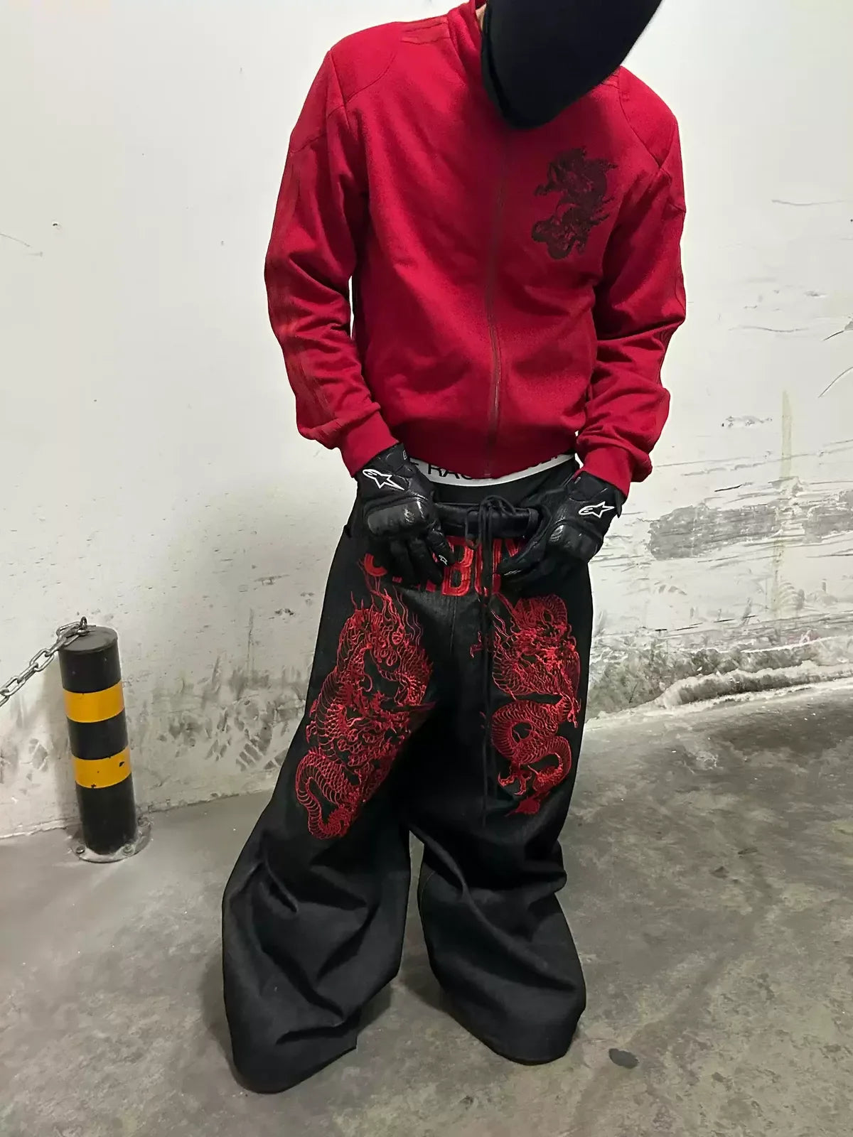 The Shibuya Dragon Graphic Jeans styled from the front with a red jacket