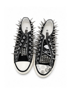 Black spiked low-top sneakers with skull patches and gear accents, top view