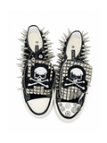 Black spiked low-top sneakers with skull-and-crossbones patches, top view