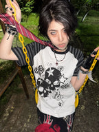 White Skull Leopard Raglan Graphic Tee styled with colorful chains on a swing