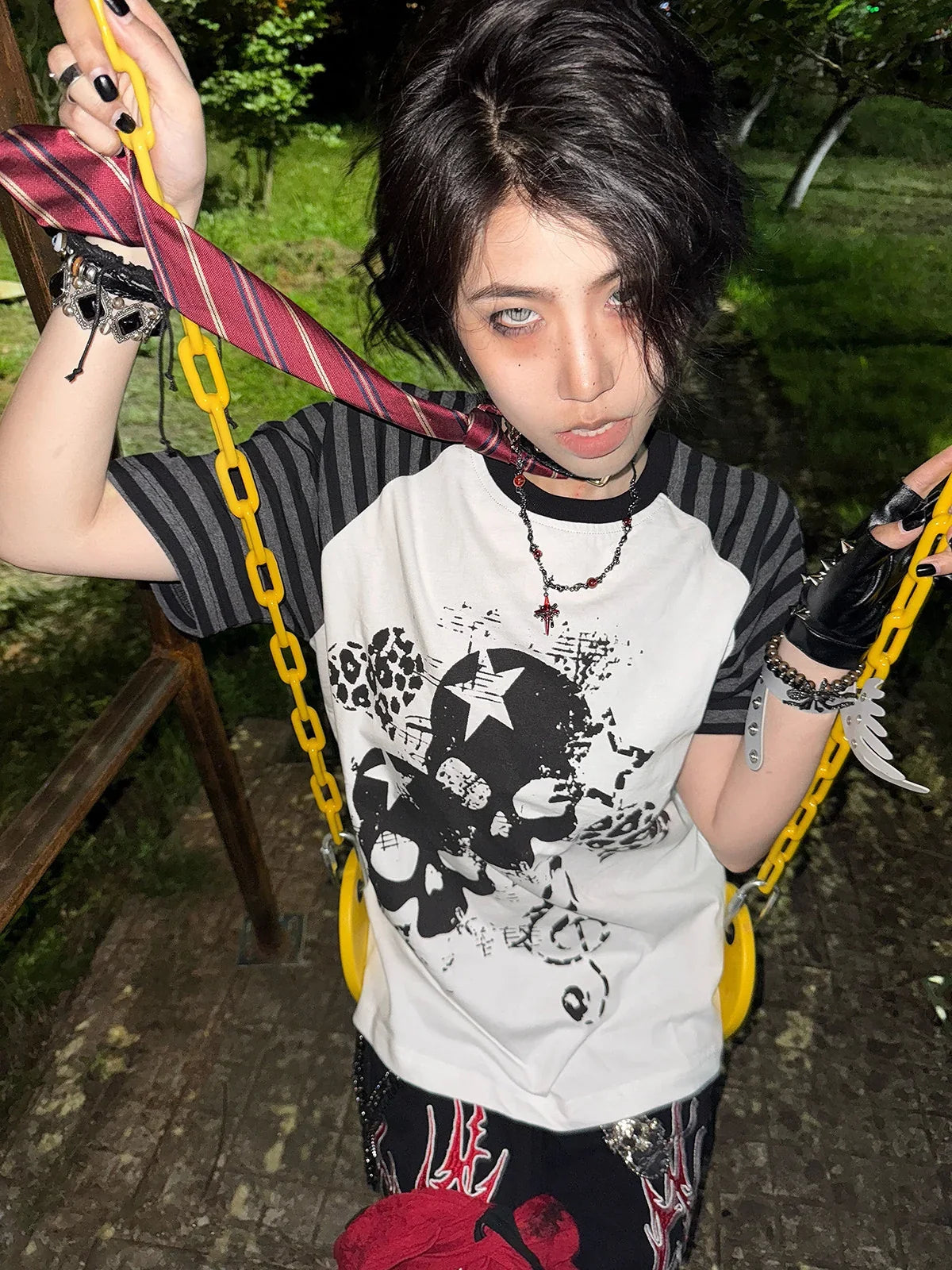 White Skull Leopard Raglan Graphic Tee styled with colorful chains on a swing