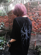Model wearing the black Thorned Spider Loose Graphic Tee, back spider graphic